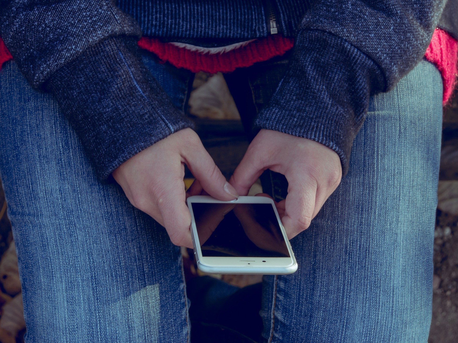 Persona con un celular en la mano leyendo una información