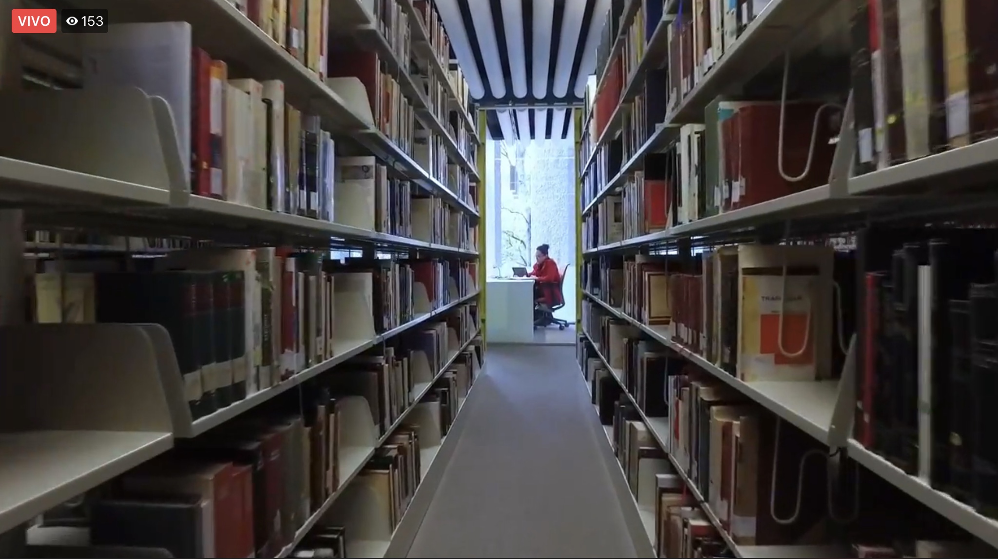 Estanterías de la biblioteca con personas al fondo